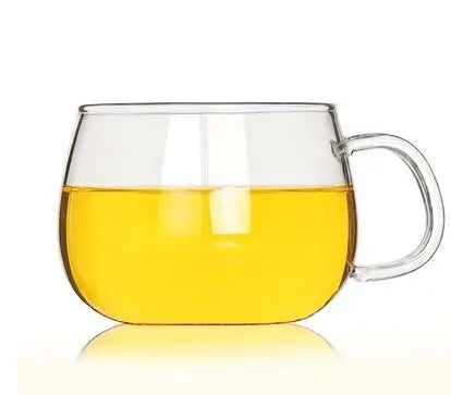 Clear glass mug filled with yellow liquid on a white background