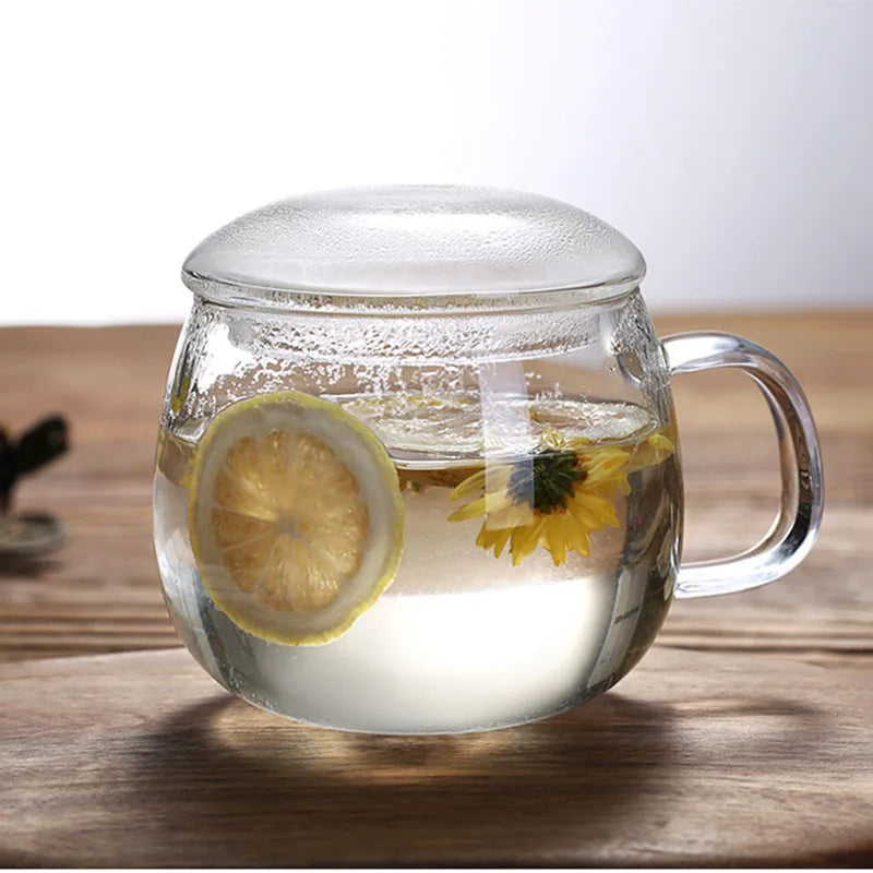 Clear glass mug with lemon slice and sunflower on a wooden surface