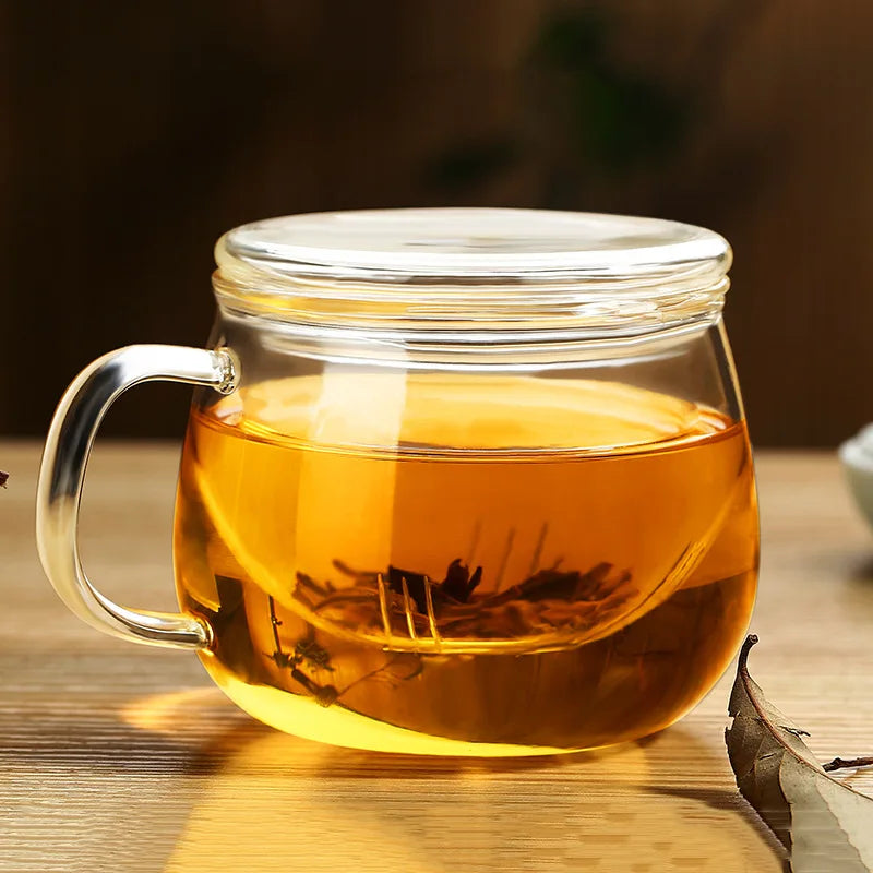 Clear glass mug filled with yellow tea on a wooden surface
