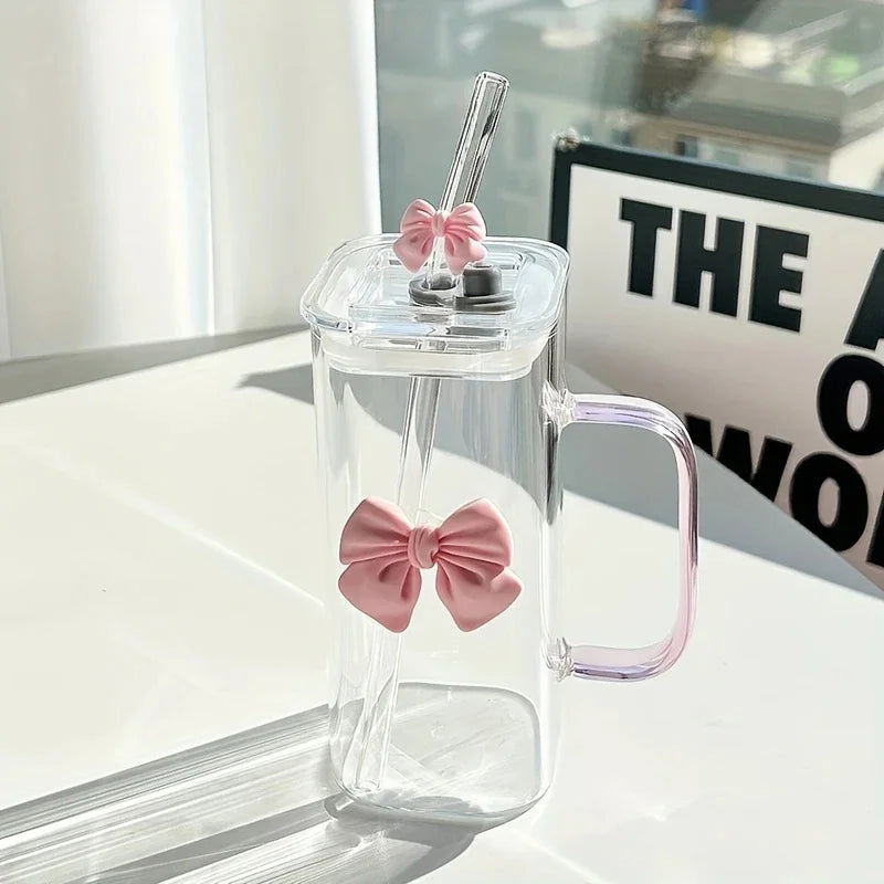 Clear glass mug with pink bow design on a white surface
