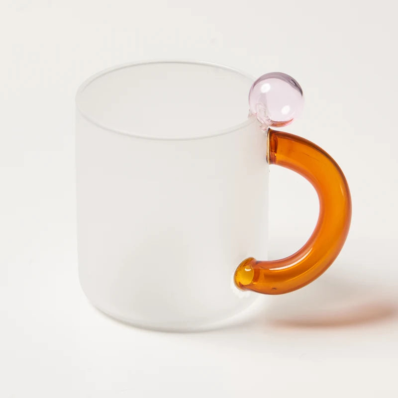 White mug with a transparent amber handle on a white background