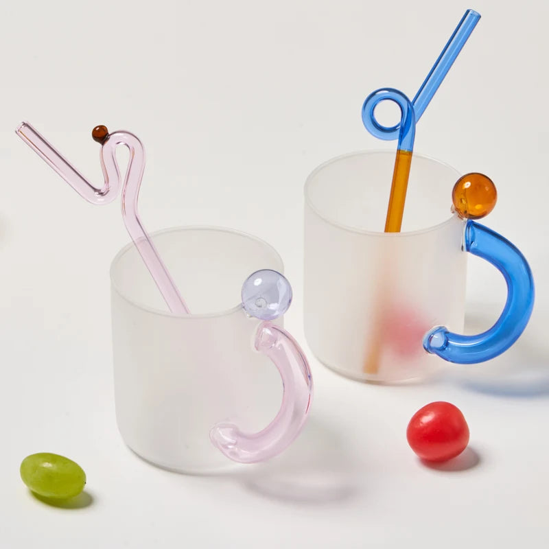 Two mugs with colorful straws and handles on a white background