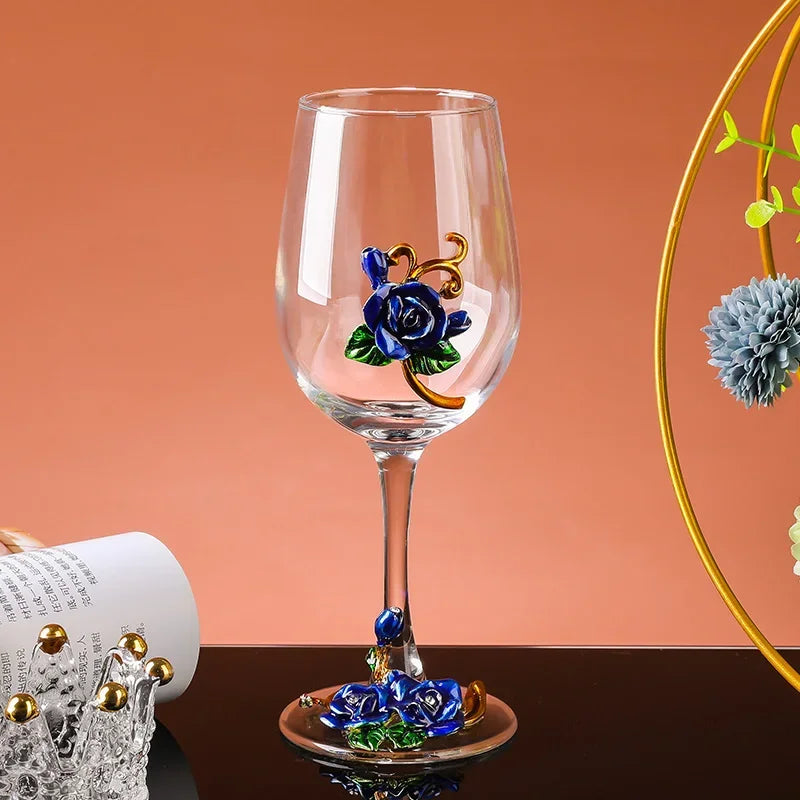 Wine glass with decorative blue roses on a brown surface and orange background