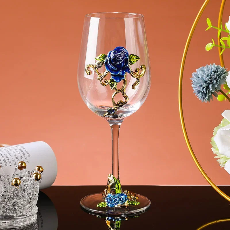 Decorative wine glass with blue rose design on a peach-colored background