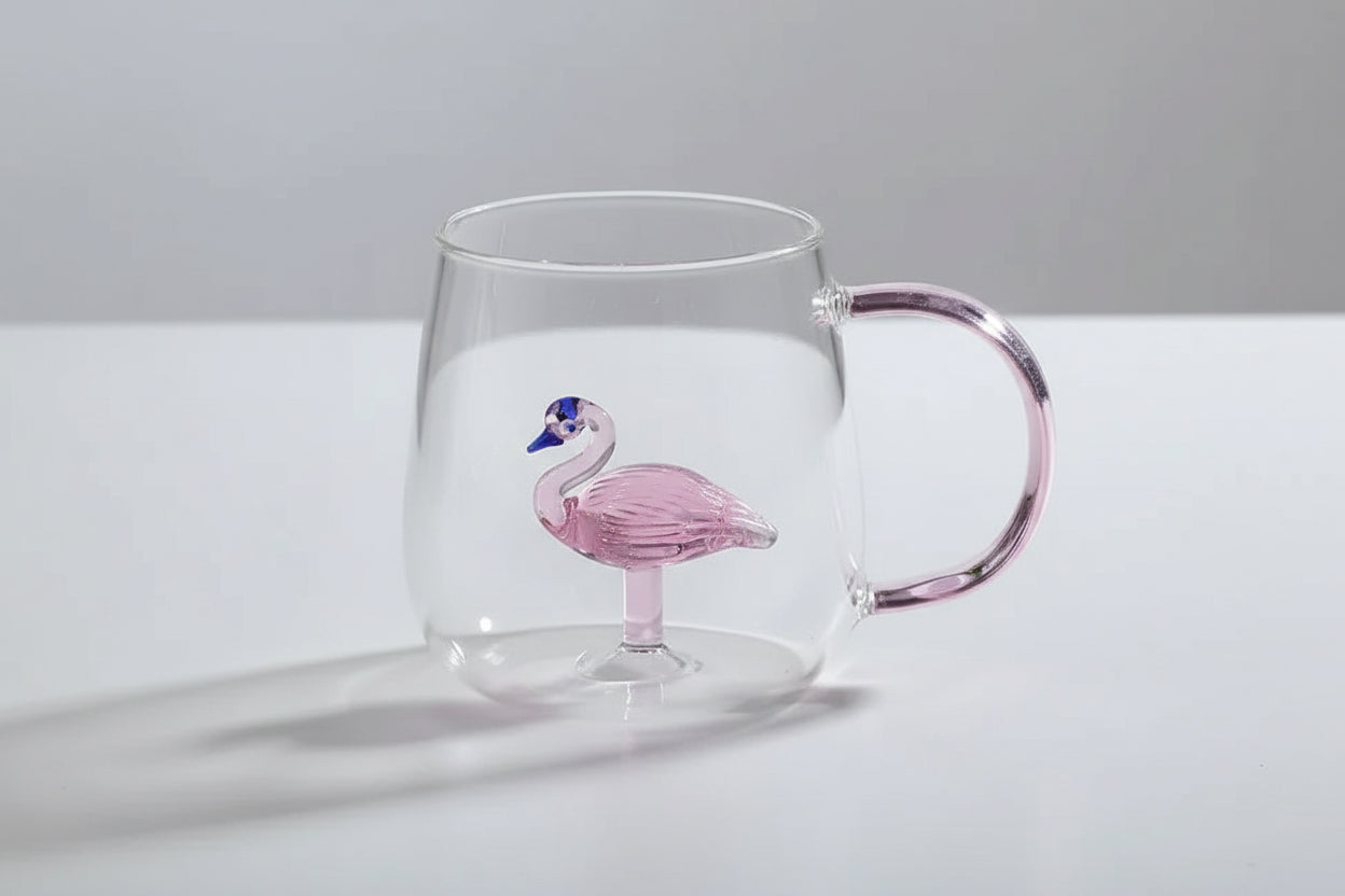 Clear glass mug with pink flamingo design on a white surface