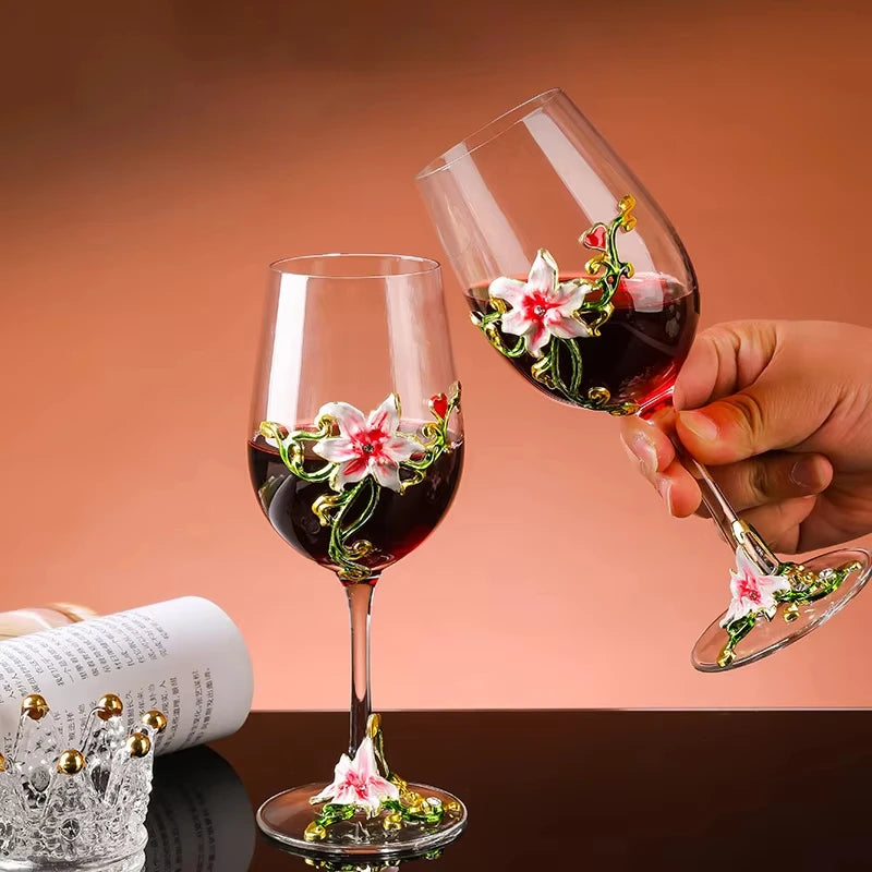 Two wine glasses with floral decorations being held against a warm background