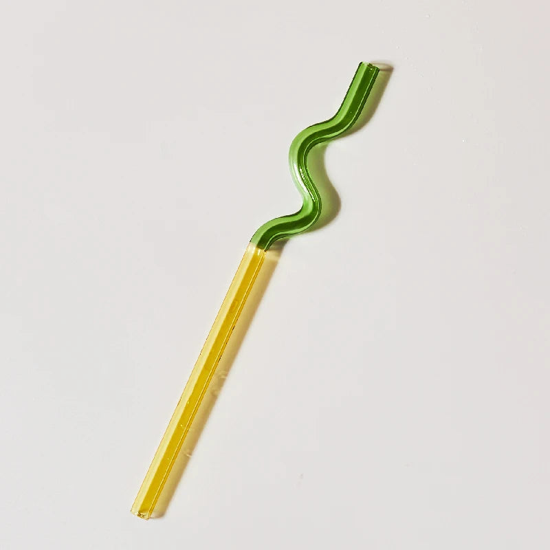 Green and yellow wavy straw on a light gray background