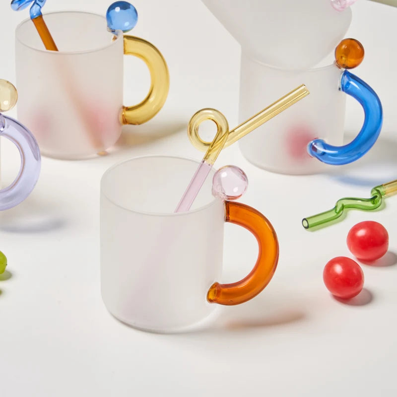 Colorful glass mugs with unique handles on a white background