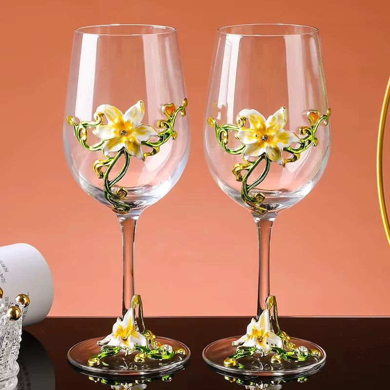 Two decorative wine glasses with floral designs on a peach background