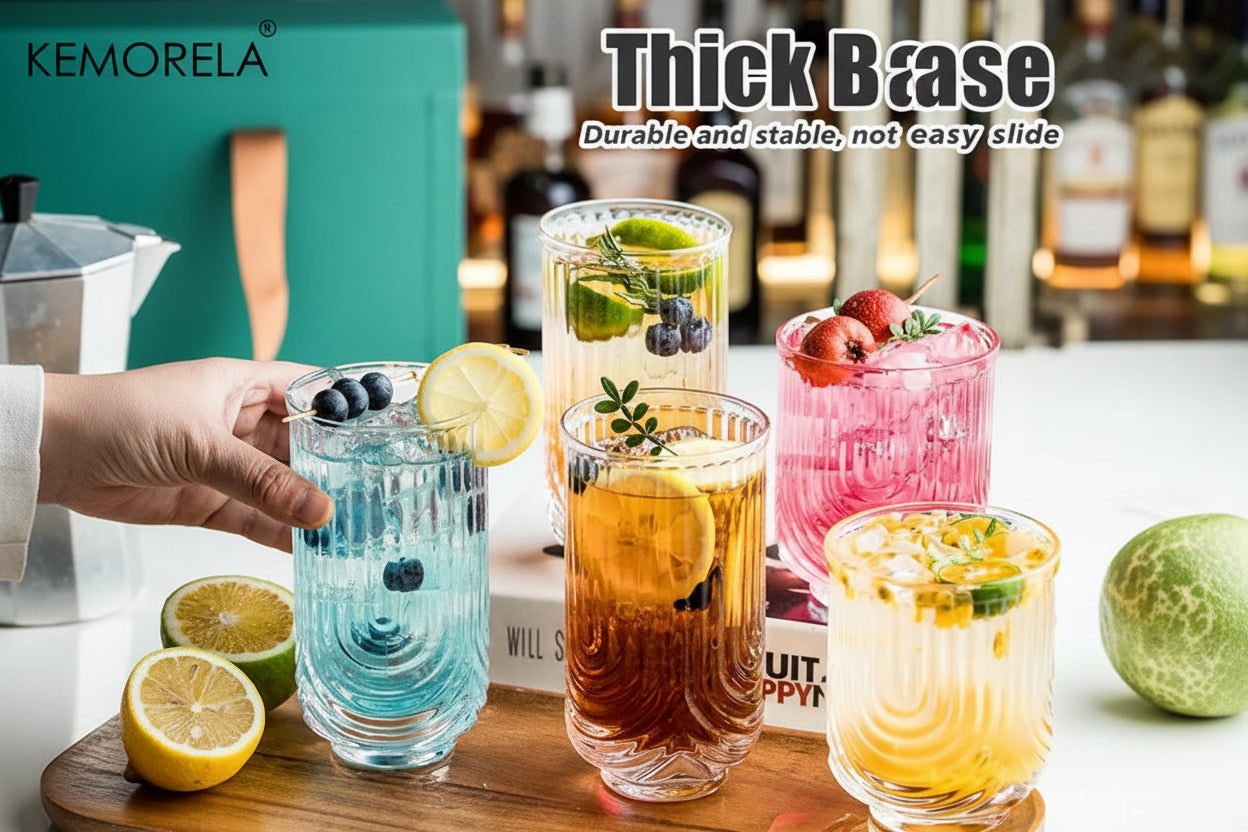 Glass tumblers with drinks on a wooden tray, featuring KEMORELA branding.