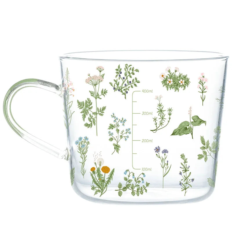 Clear measuring cup with floral designs and measurement markings on a white background