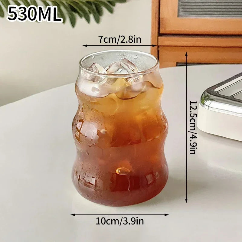 Glass with iced drink and measurements on a white surface